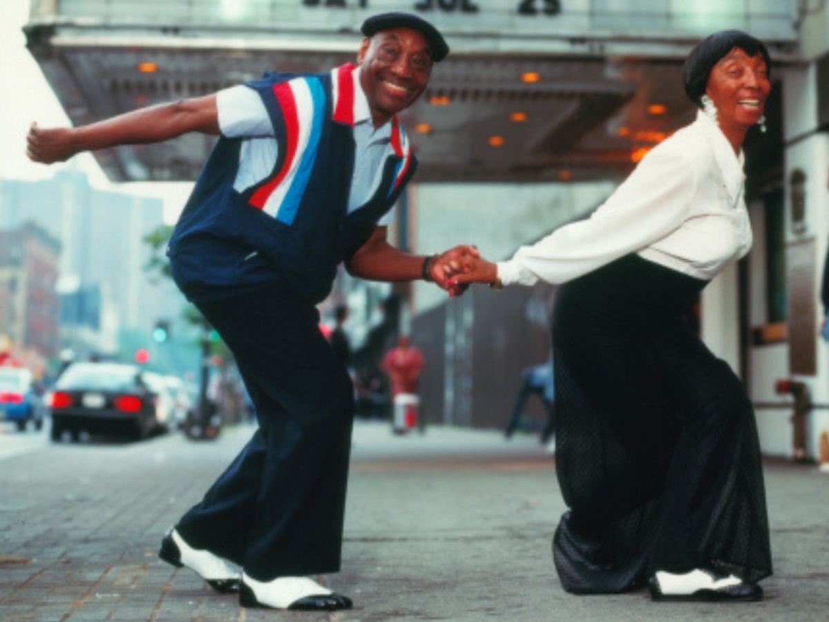 Frankie Manning and Norma Miller dancing outside a theatre during the revival years